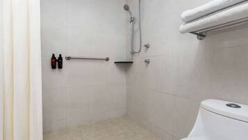 A bathroom with a shower, a toilet, and a towel rack.