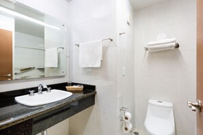 A bathroom with a sink, mirror, towel rack, and toilet.