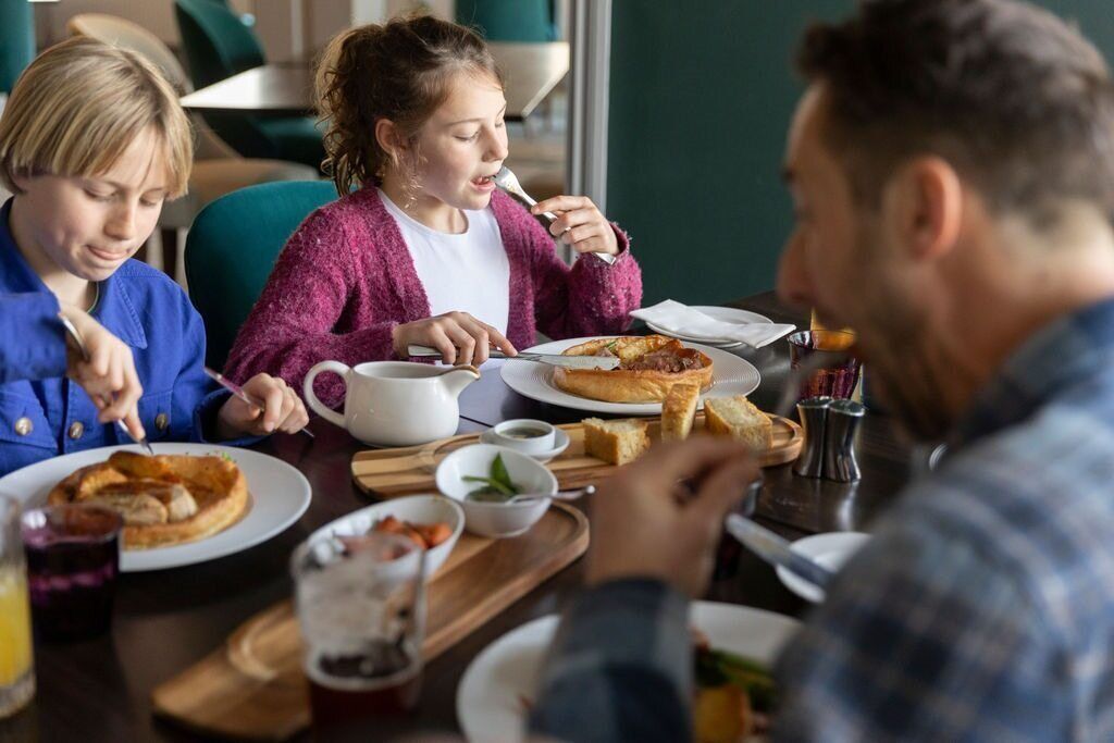 A dining table with plates of food, a pitcher, and a cup.