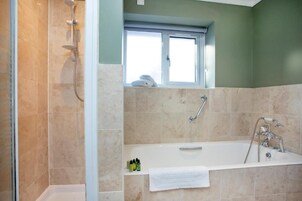 Un baño con ducha, bañera y ventana.