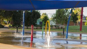 Un espacio para jugar con agua, con columnas de colores y una fuente.