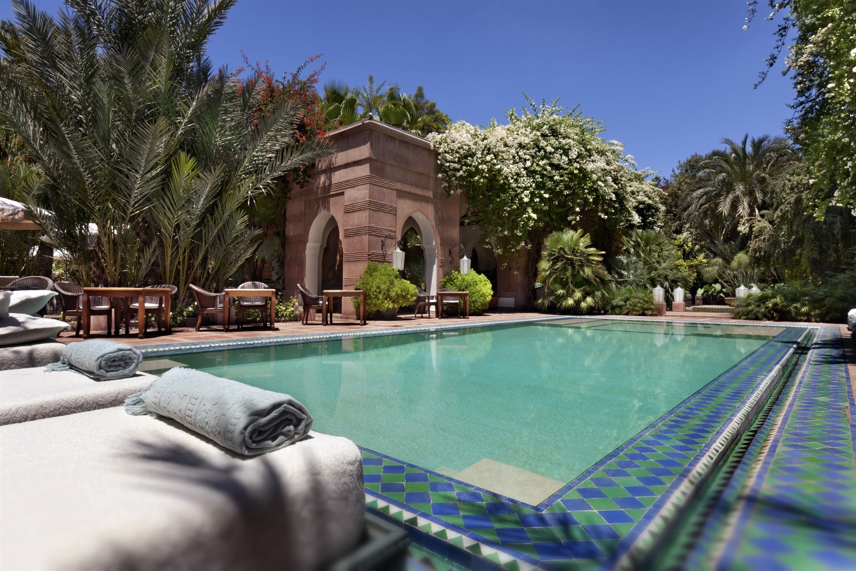 Una piscina al aire libre de temporada, sombrillas, tumbonas