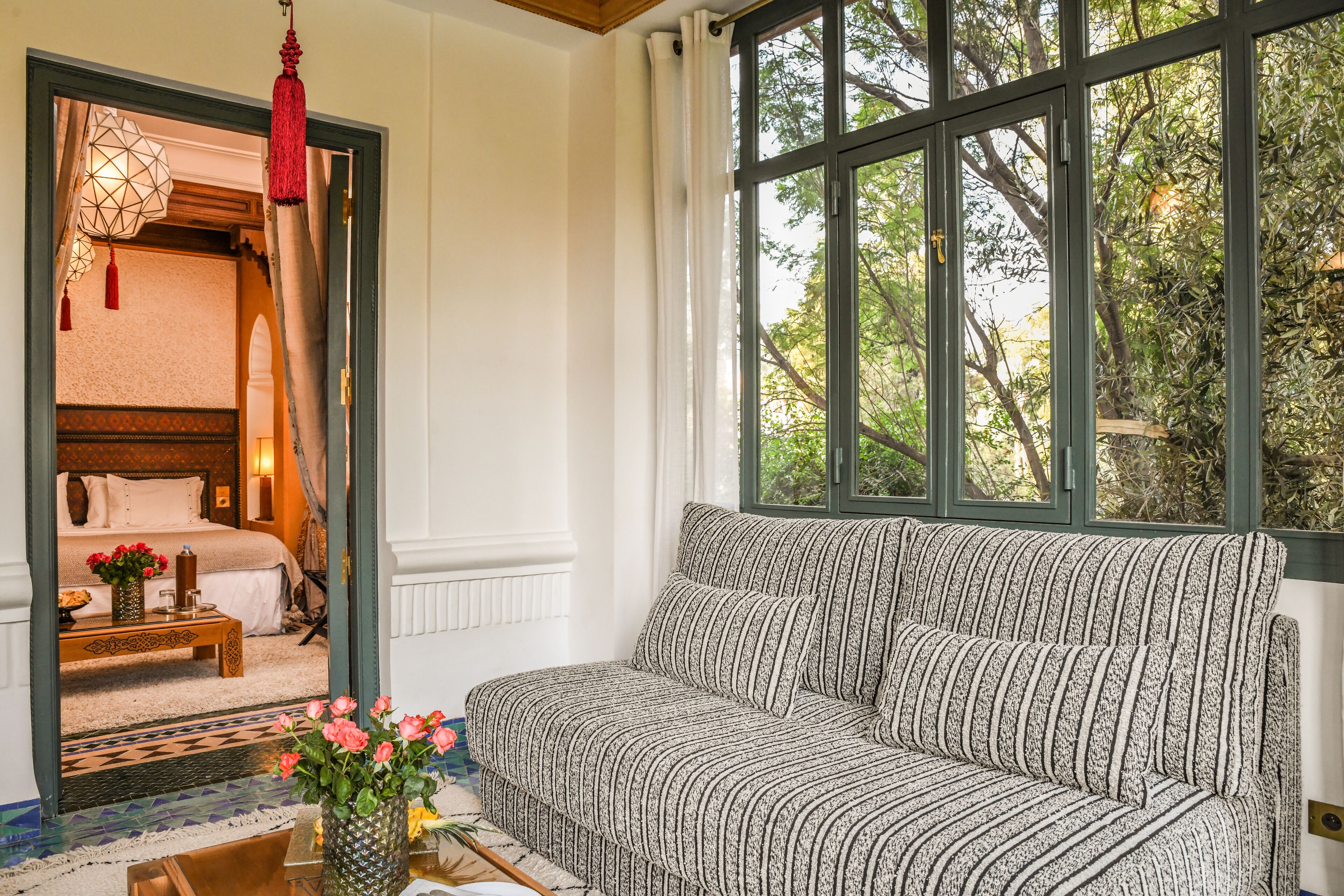 Una habitación acogedora con sofá, cama y ventana con vistas a árboles.