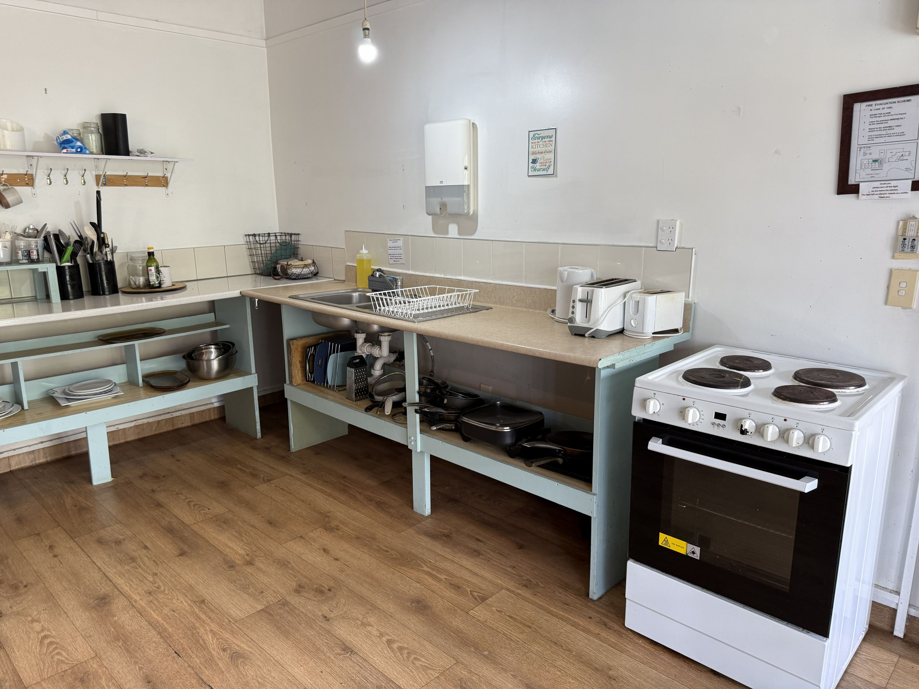 A kitchen with a stove, sink, and various utensils.