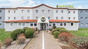 Un hotel B&B con entrada central, varias ventanas y tejado de tejas.