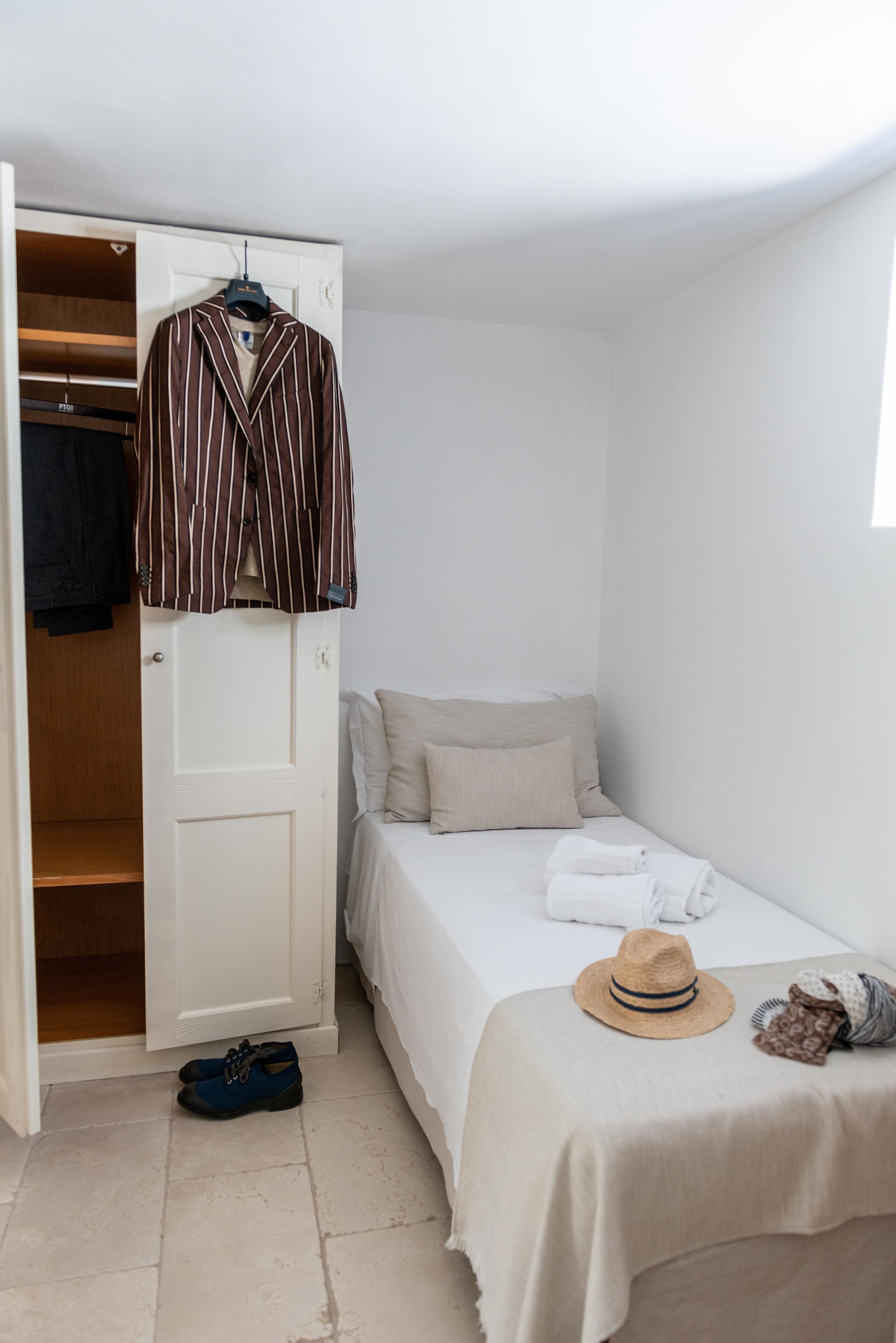 Un dormitorio con cama, perchero y armario.
