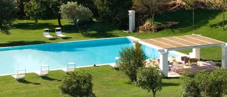 Seasonal outdoor pool, open 10:30 AM to 7:00 PM, pool loungers