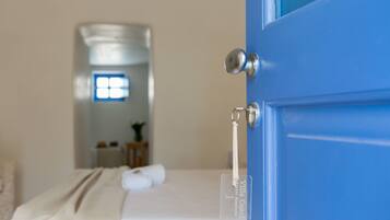 Una habitación con una cama, una puerta azul y una ventana con vistas.