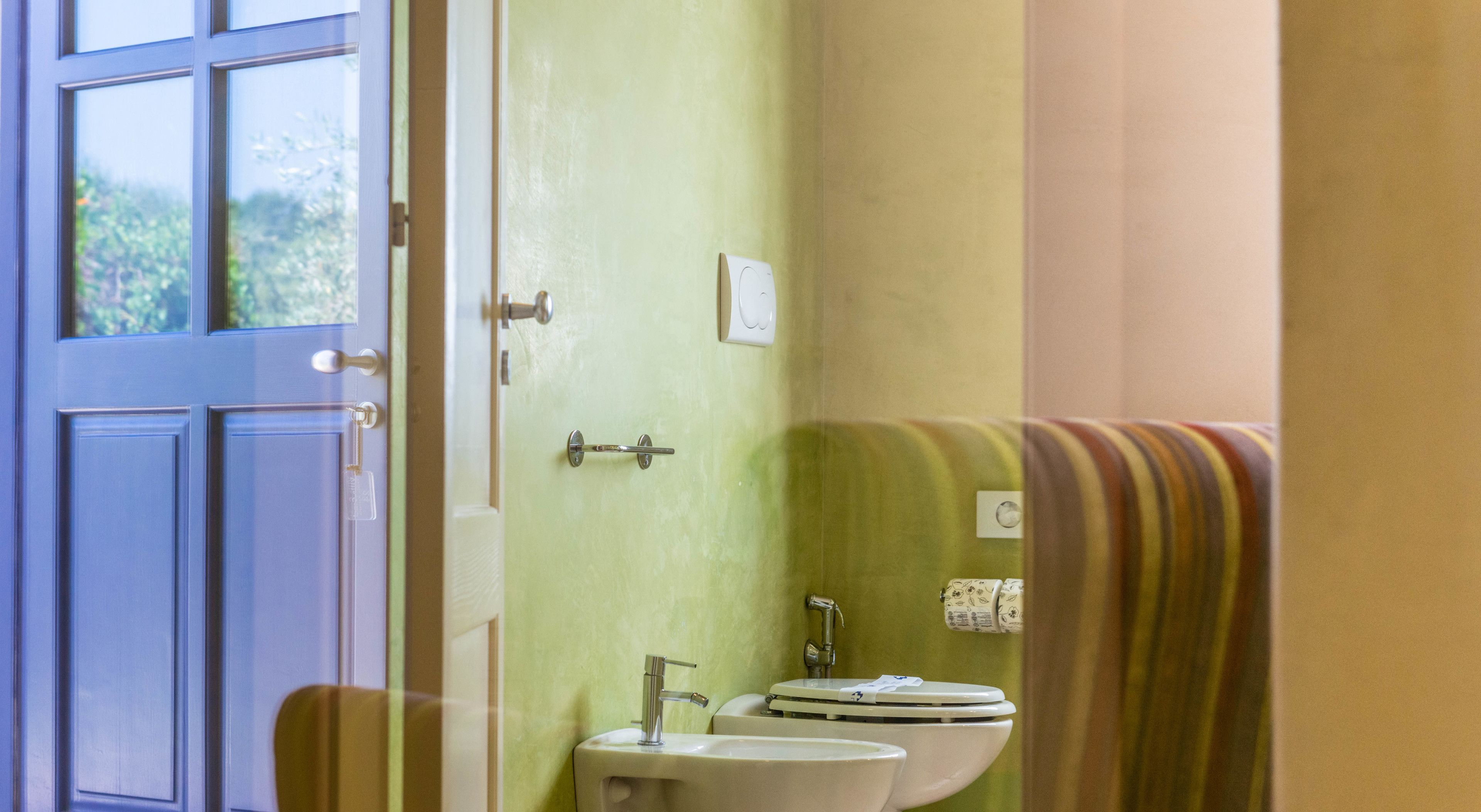 Un baño con lavamanos, inodoro y toallero.