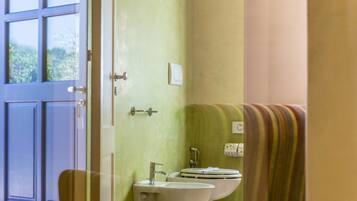 Un baño con lavamanos, inodoro y toallero.