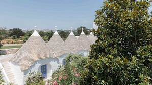 Una hilera de edificios blancos con techos cónicos y un árbol en primer plano.
