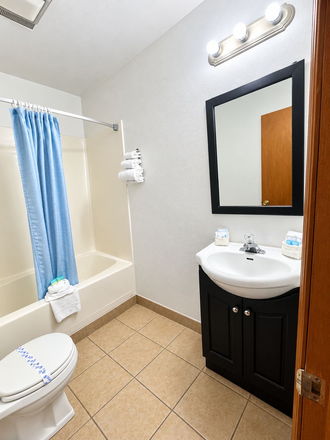 A bathroom with a bathtub, toilet, sink, and mirror.