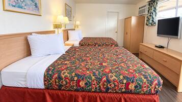A hotel room with two beds, a TV, a wardrobe, and a painting on the wall.