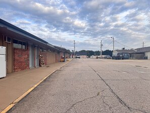 A street with buildings, a gravel road, and utility poles. - Budget Lodge Inn Abilene KS (Abilene)