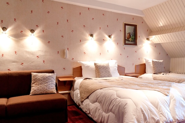 Una habitación de hotel con una cama grande, un sofá y un cuadro en la pared.