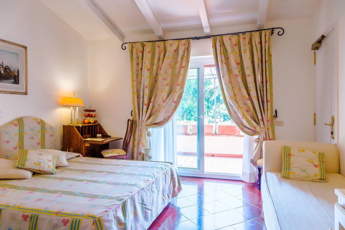 Un dormitorio con cama, sillón, escritorio y sofá.