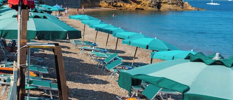 På stranden, vit sandstrand, solstolar och parasoller