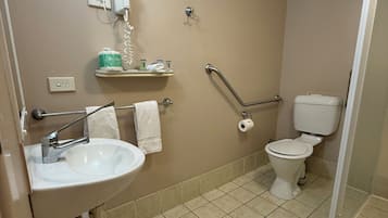 Une salle de bain équipée d’un lavabo, de toilettes et d’un sèche-mains.