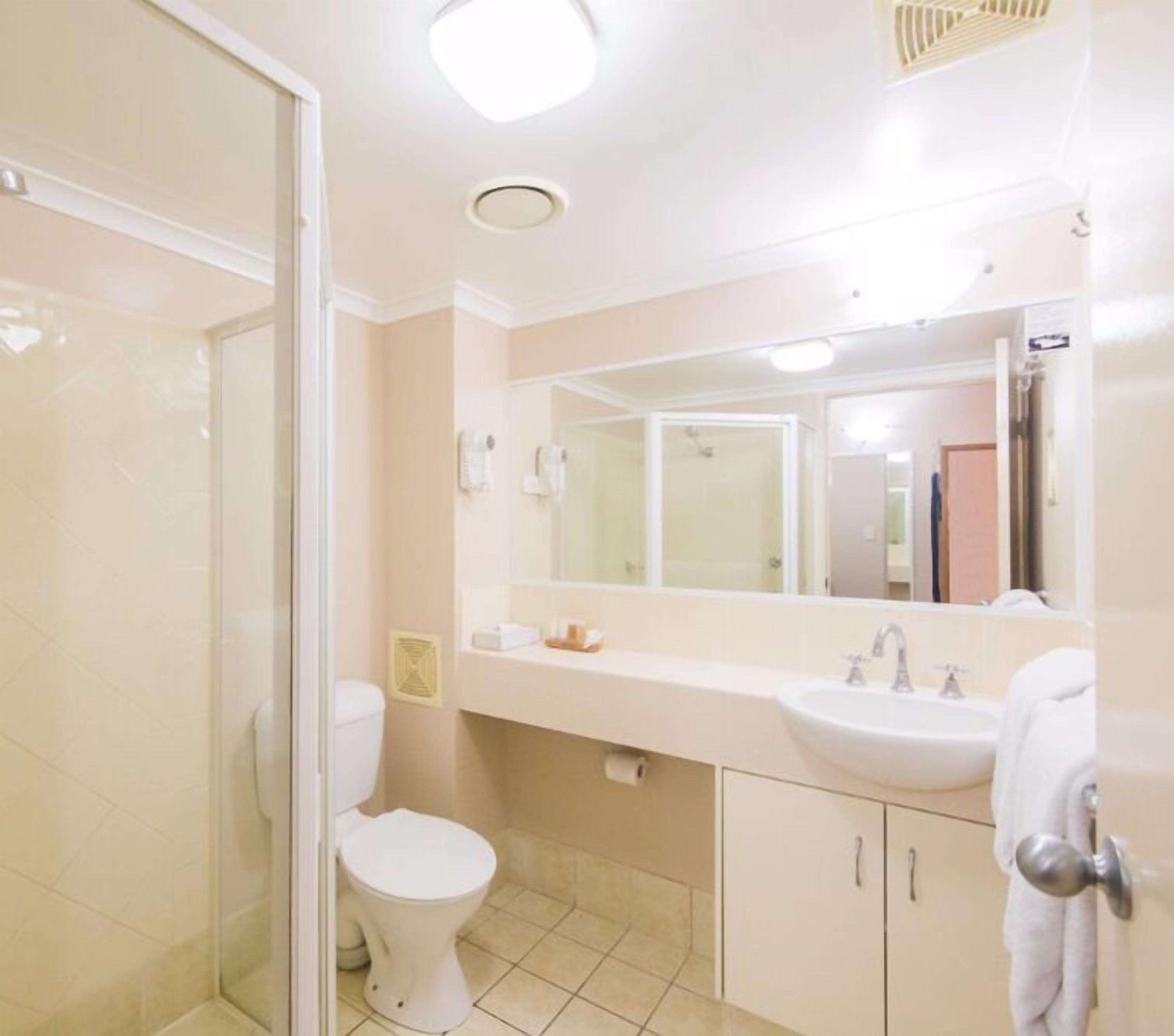 Een badkamer met toilet, wastafel en douche.