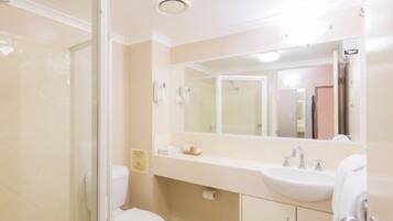 A bathroom with a toilet, sink, and shower.