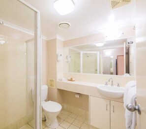 A bathroom with a toilet, sink, and shower.