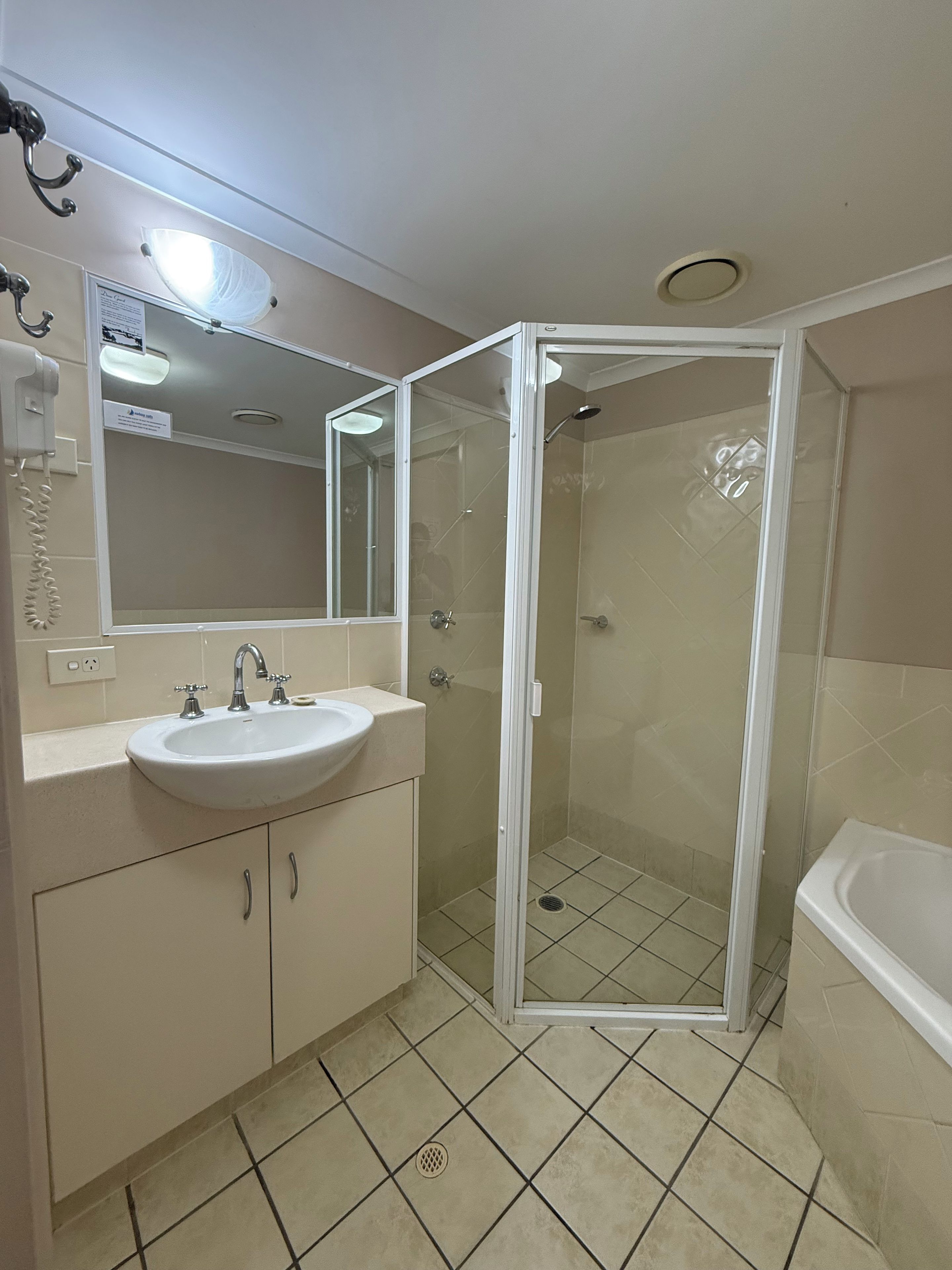 Un baño con lavamanos, espejo, cabina de ducha y bañera.