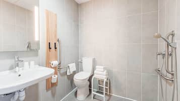 Un baño moderno con lavamanos, inodoro y ducha.