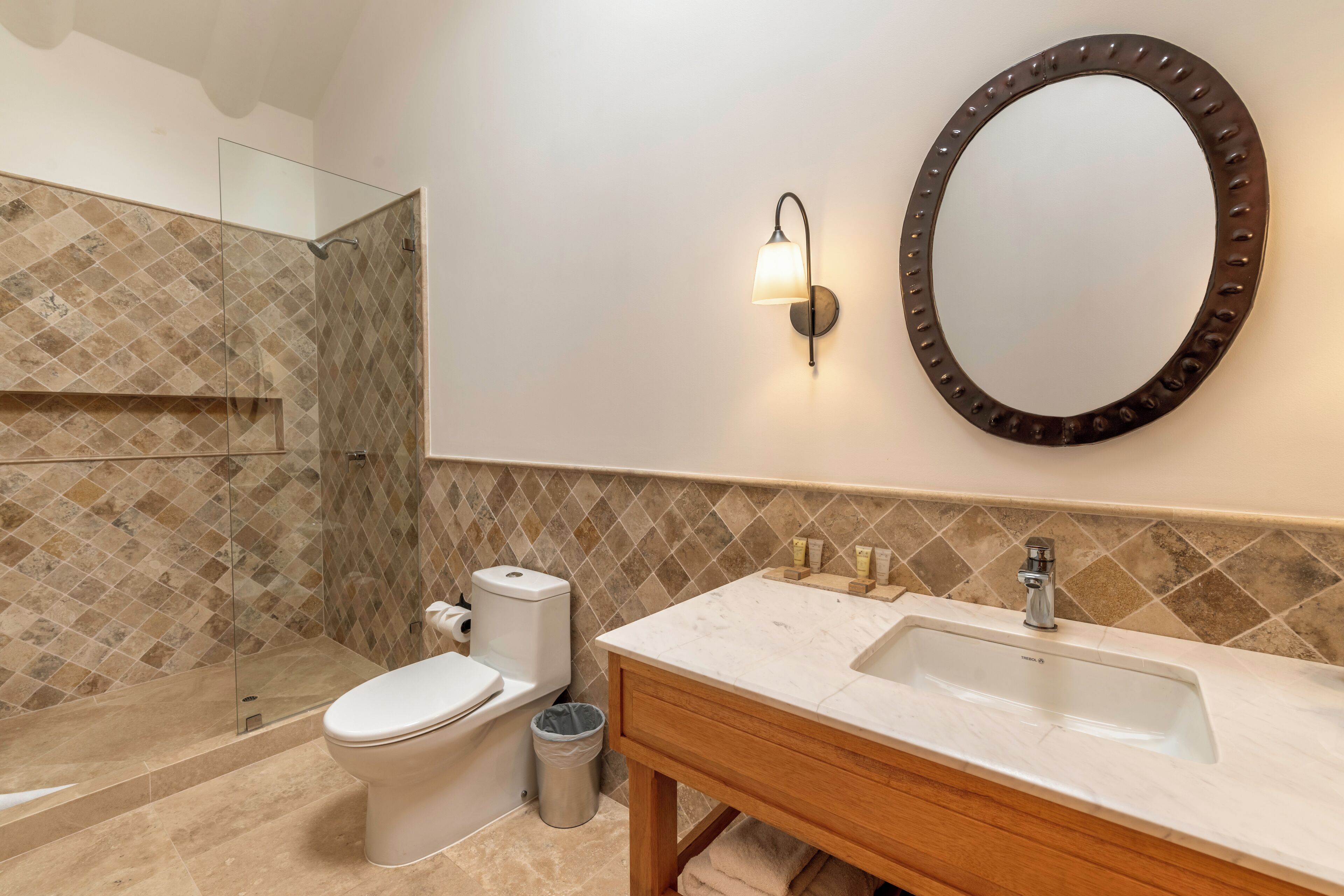 Un baño con inodoro, lavabo y espejo.