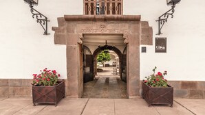 A building entrance with a stone archway, two lanterns, and a sign for "CIPRI". - La Casona de Yucay Hotel (Yucay)