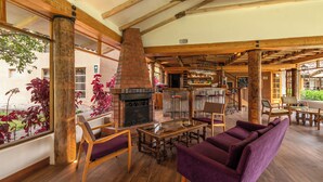 A cozy lounge area with wooden furniture, a fireplace, and a bar. - La Casona de Yucay Hotel (Yucay)