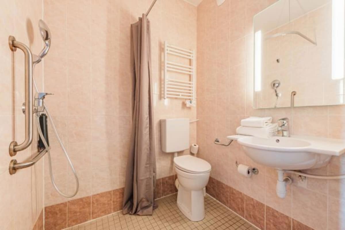 Un baño con ducha, inodoro y lavabo.