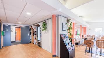 Eine geräumige Lobby mit Holzboden, einer Rezeption und Sitzbereichen.