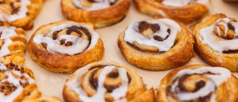 A tray of freshly baked cinnamon rolls with icing.