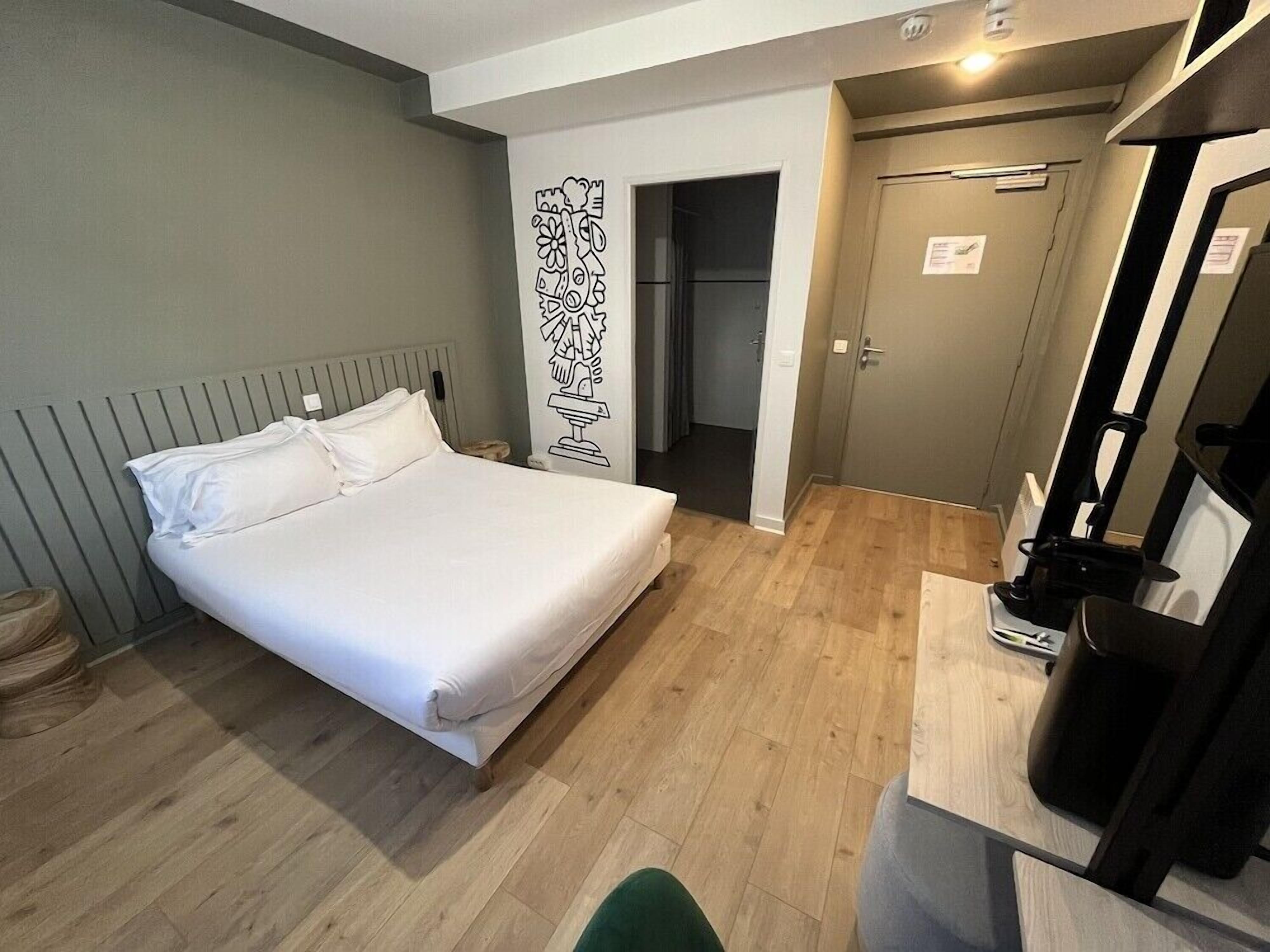 Un dormitorio con una cama, un escritorio y una puerta que da a un baño.