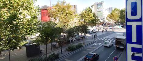 A street view with a hotel sign, a bus stop, and a pedestrian crossing.