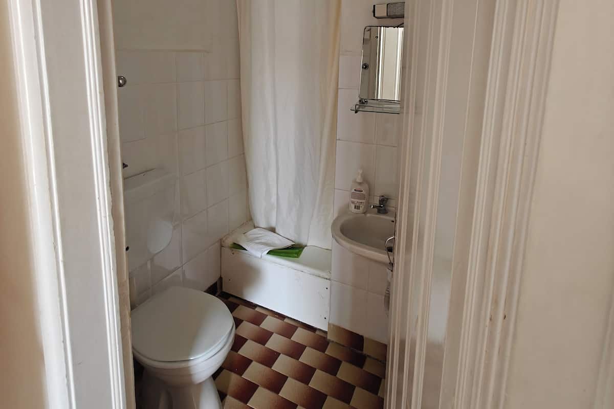 Een bad/douchecombinatie, een regendouche, handdoeken