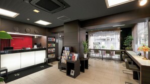 A modern reception area with a counter, seating, and a view of the outside. - Hotel Horidome Villa (Tokyo)