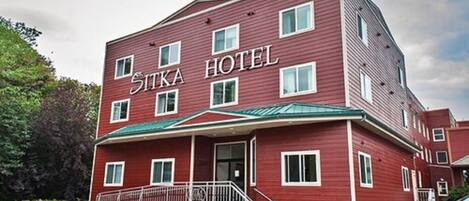 Ein rotes Gebäude mit dem Schild "SITKA HOTEL" an der Vorderseite.