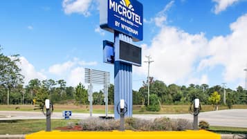 A Microtel Inn & Suites sign with a yellow curb and surveillance cameras.