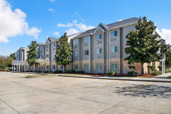 A multi-story hotel with a parking lot in front.