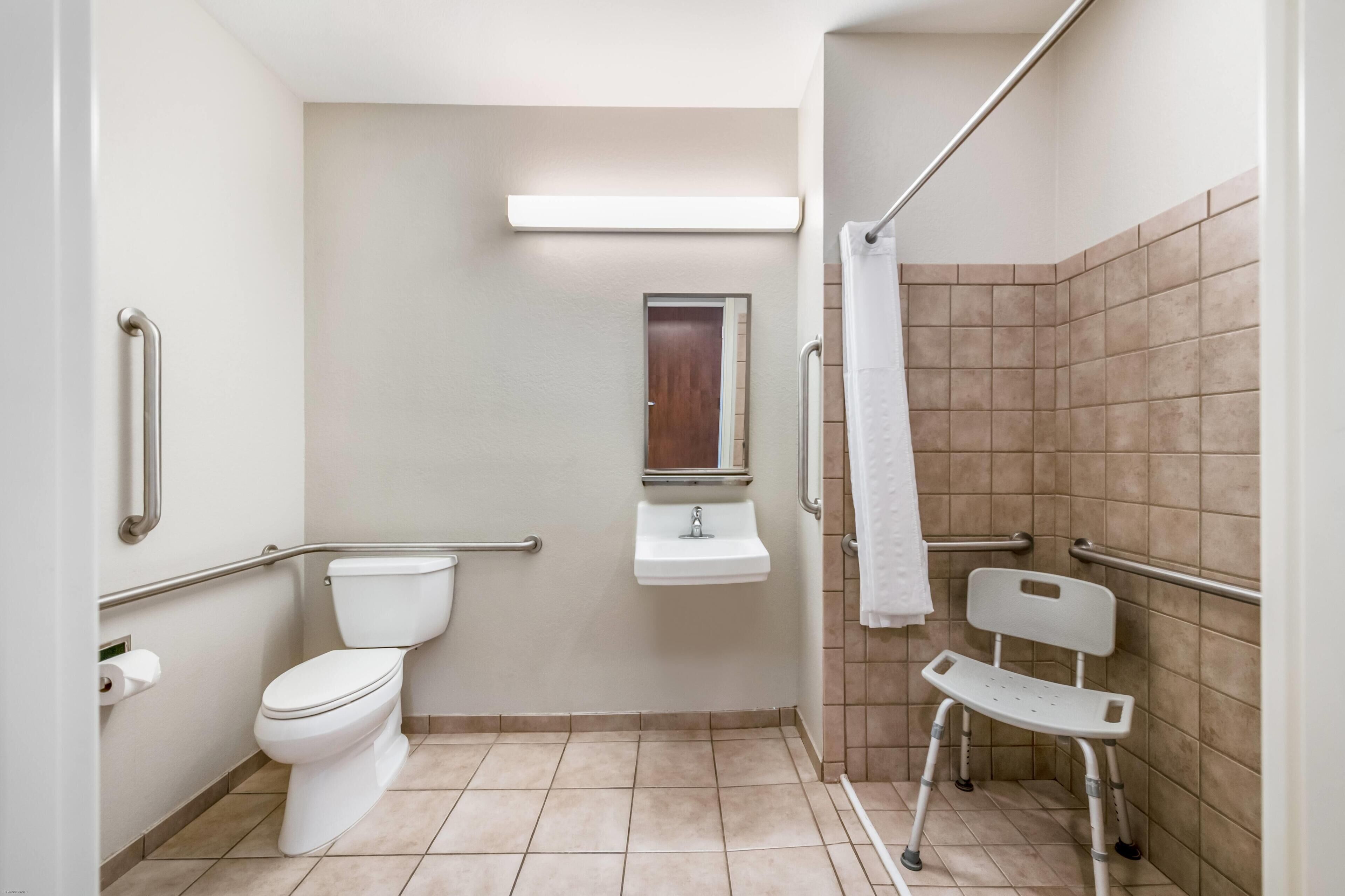 A bathroom with a toilet, sink, and shower area.