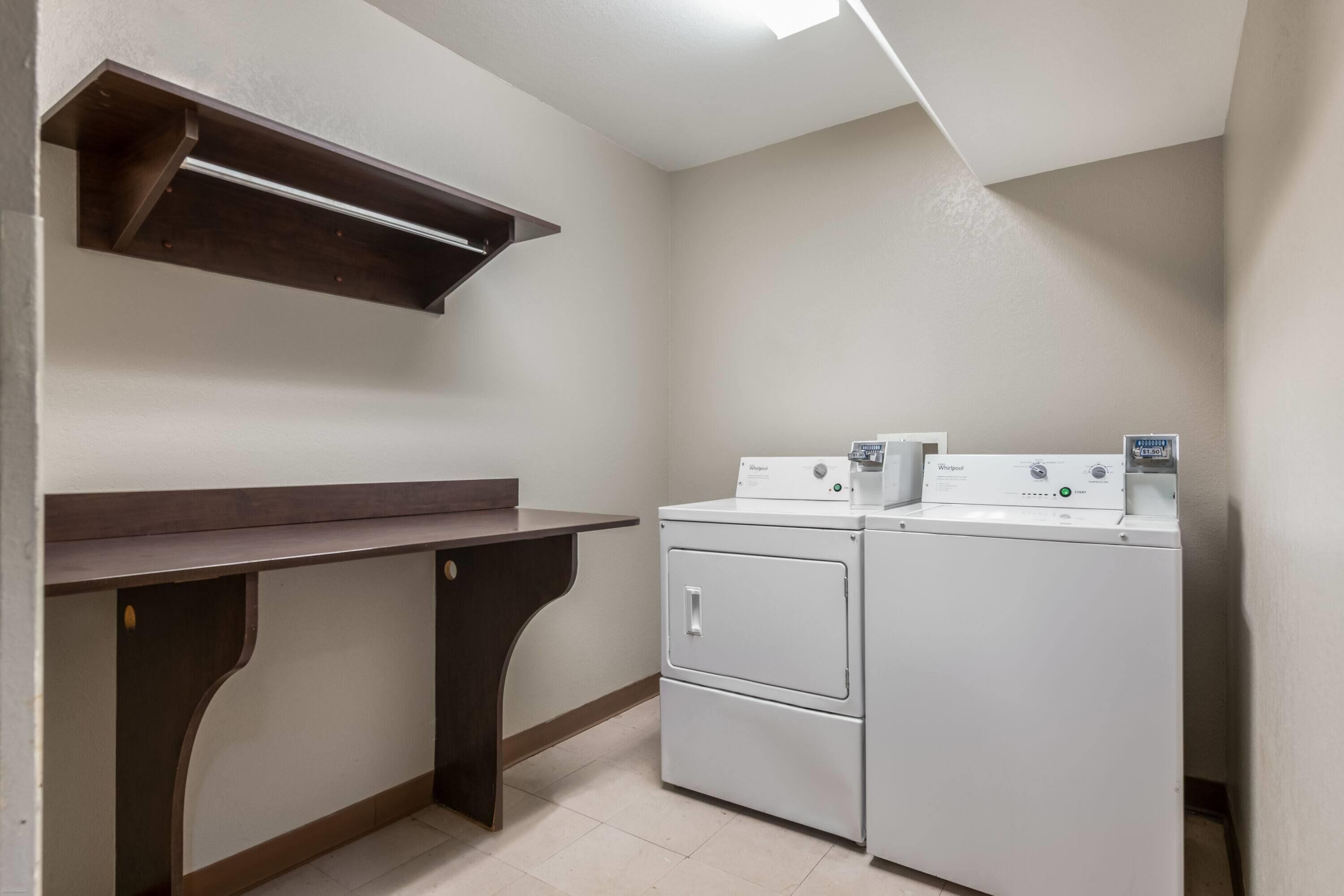 A laundry room with a built-in shelf, a washing machine, and a dryer.