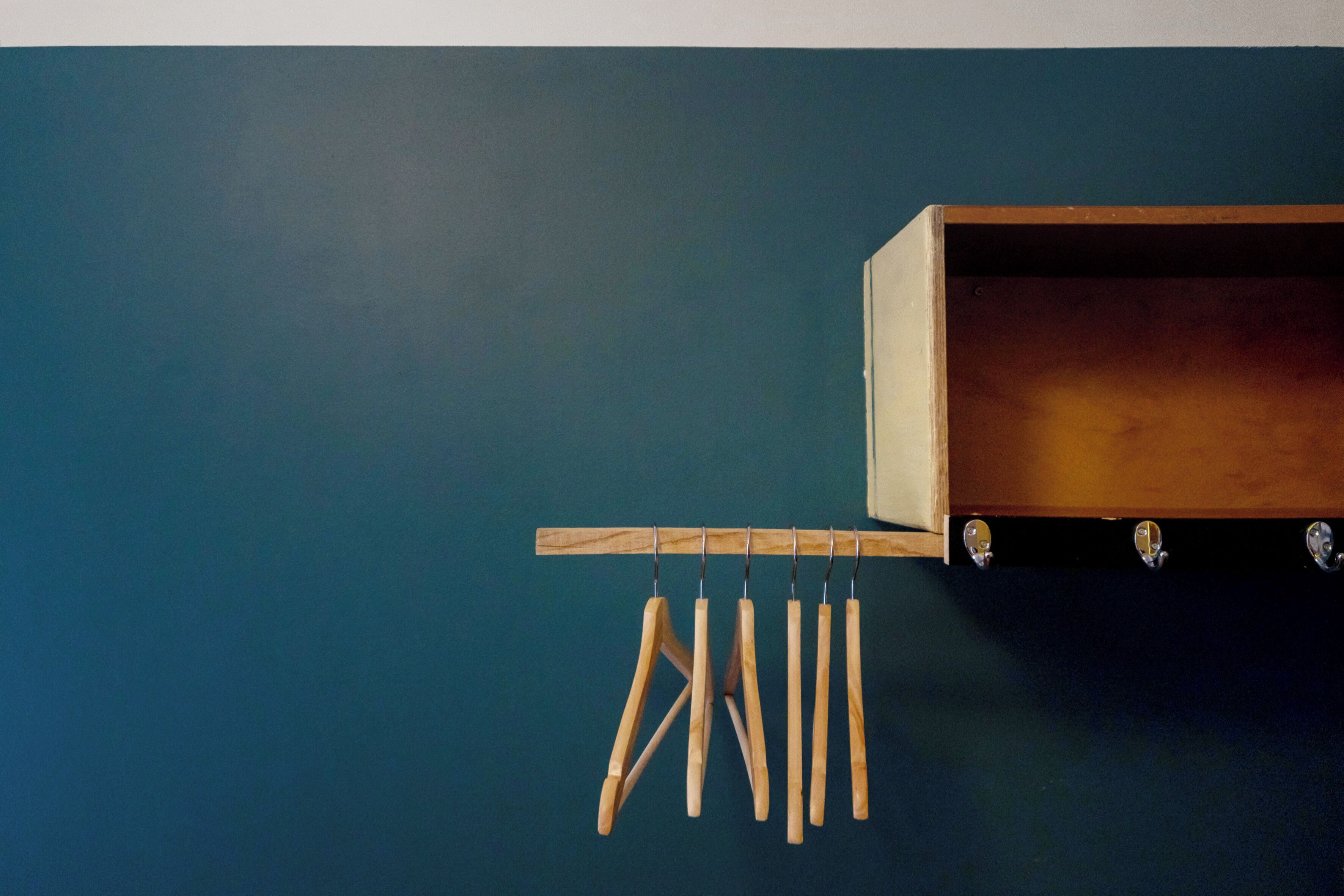 Un tendedero de madera con ropa colgada, sujeto a la pared.
