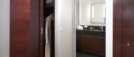 A modern bathroom with a dark wood vanity, a mirror, and a towel rack.