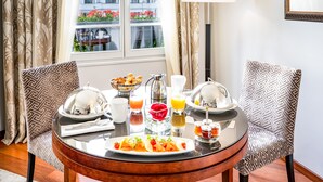A breakfast setting with a table, chairs, and a window view. - Relais Spa Val d'Europe (Chessy)