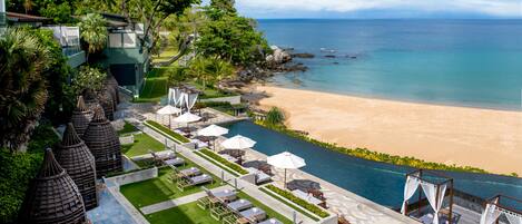 Un resort con zona de piscina, vista al mar y jardines tropicales.