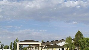 A building with multiple roofs and a clear sky with clouds. - River Terrace Green River (Green River)