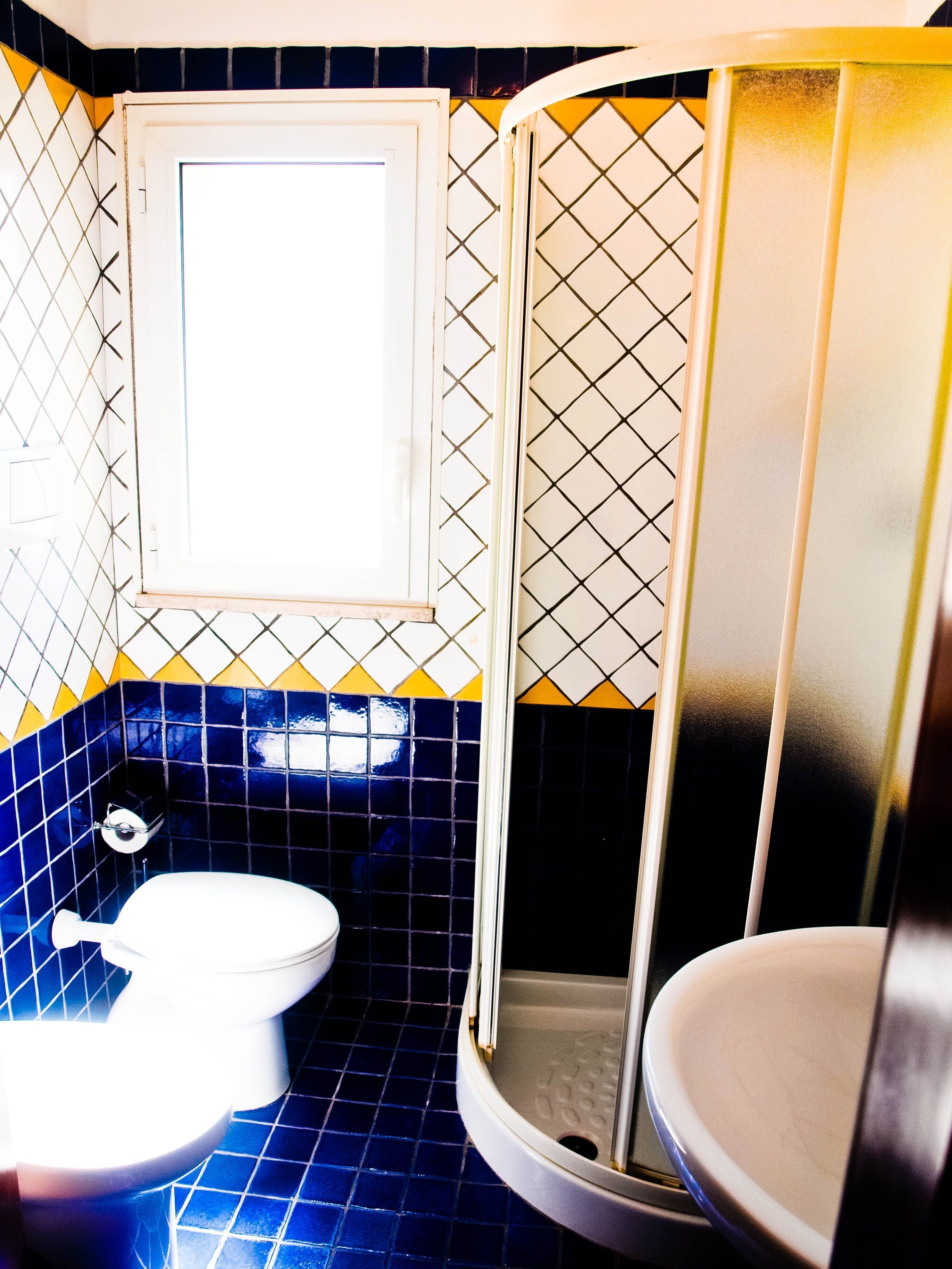A bathroom with a toilet, a sink, and a shower.