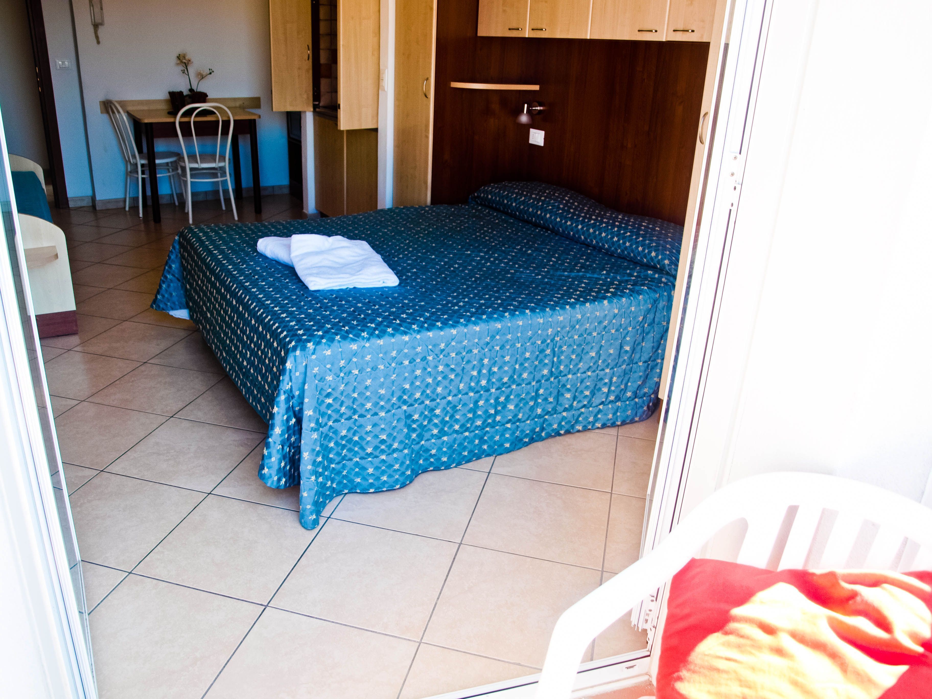 A room with a bed, a desk, and a chair.