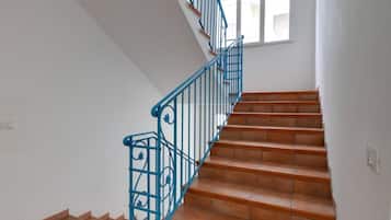 Eine Treppe mit blauen Metallgeländern und Terrakottafliesen.
